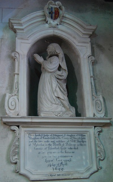 Monument to Margaret Brydges in Holy Rood church, Mordiford: her white effigy kneeling at prayer in an arched niche, with a coat of arms above and the inscription tablet below